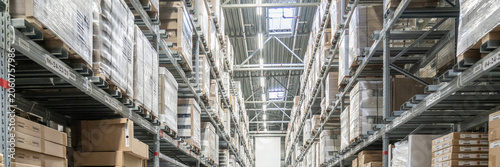 Rows of shelves with boxes in big warehouse