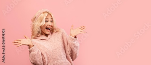 Fotografija Joyful Young Woman Smiling And Celebrating With Outstretched Arms At Studio Setting, Expressing Happiness And Excitement In A Vibrant Pink Background