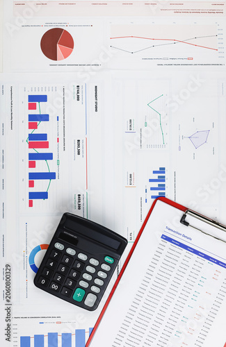 Vertical top view of financial report with charts, graphs, calculator, and clipboard on office desk. Business accounting data dashboard, tax budget planning, and investment analysis concept.