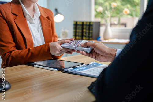 Принти на полотні Close view of a cash payment exchanged across a lawyer’s desk with legal papers, gavel and scales in the background, suggesting bribery, corruption or an illegal business deal