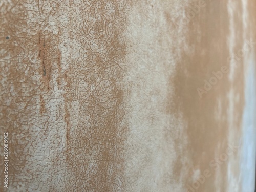 Aged cracked plaster texture background with light brown earth tones.