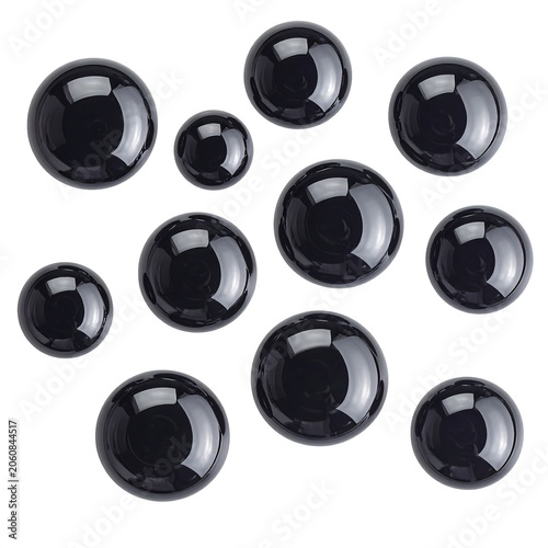 Various sizes of polished black spheres arranged on white background