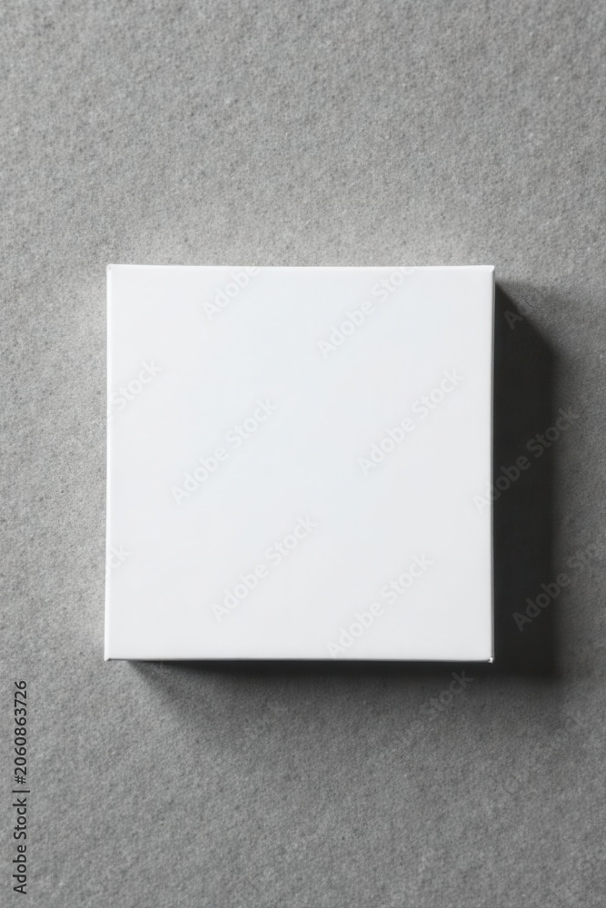 Fototapeta premium Blank white square card, gift box on grey concrete Perfect for branding , packaging, template