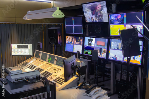 Interior view of a fully equipped broadcast studio with multiple screens and control consoles.