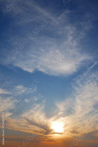 Soft clouds drift against a vast blue sky