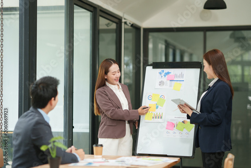 Confident Businesswoman Presenting Marketing Strategy and Using Tablet with Team