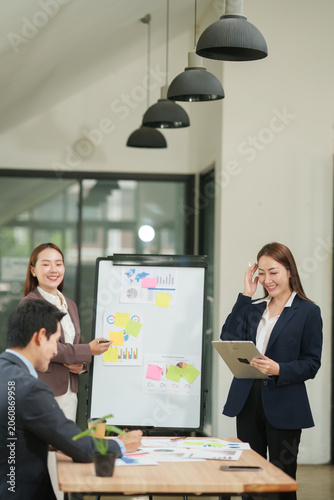 Confident Businesswoman Presenting Marketing Strategy and Using Tablet with Team