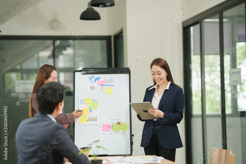 Confident Businesswoman Presenting Marketing Strategy and Using Tablet with Team