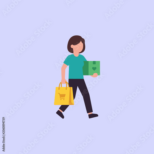 Valokuva A woman carries a shopping bag and a package while walking