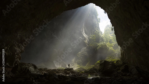 Mysterious Cave Entrance Illuminated by Natural Light in Dense Forest