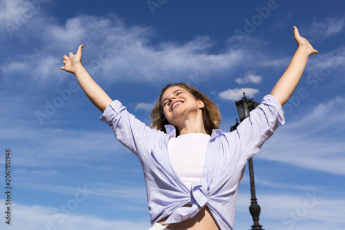 Фотография Person with arms raised smiling under a clear sky