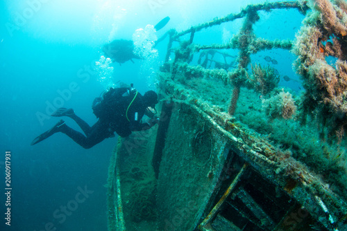 Diving near a sunken ship wreck in clear water with fish swimming around in a tropical location