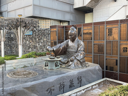 Bronze Statue of Korean Historical Figure in Suwon Market - Realistic photo of seated traditional scholar statue with table and inscriptions. Ideal for history, culture, landmark, and tourism concepts