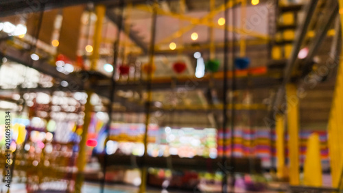 Defocused background of kids indoor play area featuring rope course obstacles and climbing frames in amusement center
