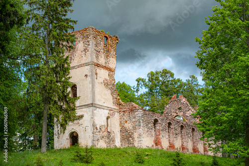 Obraz na płótnie Sunny landscape with old stone church ruins, The church was a brick building with a rectangular chancel and a protruding tower with a baroque spire