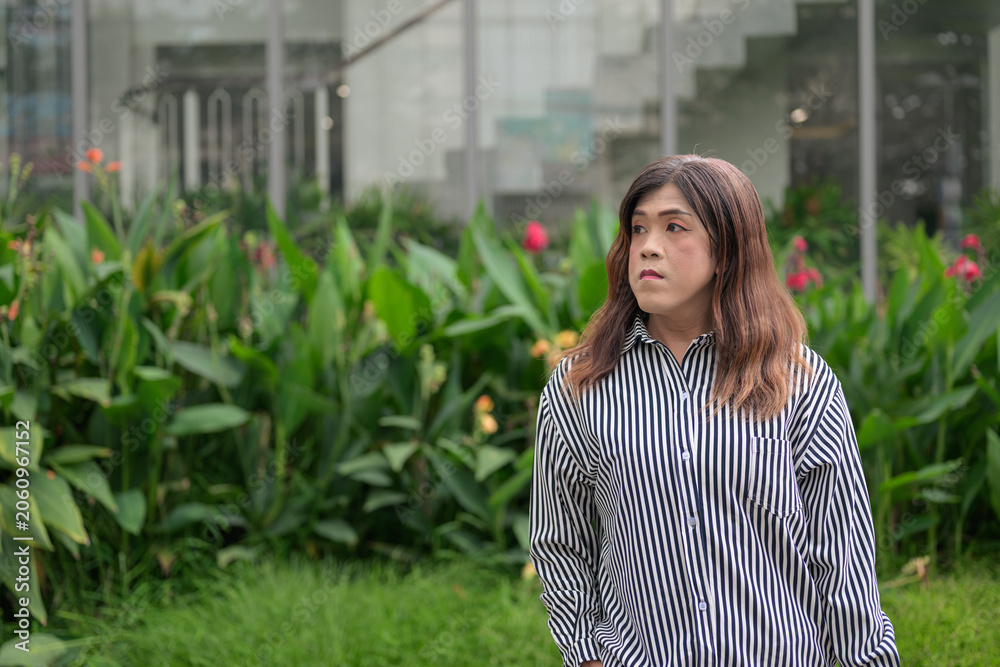 Fototapeta premium Thai Isan transgender businesswoman in 40s looking away thoughtfully outdoors