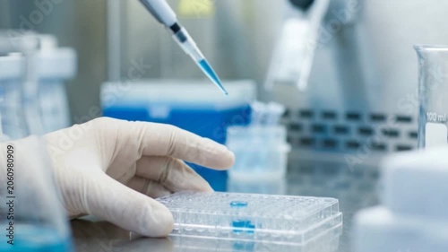 A scientist using a micropipette in a sterile laboratory environment, conducting biomedical research and advanced scientific testing in a modern facility.