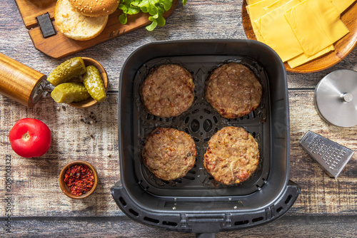 Step 7. Cooking homemade cheeseburger in kitchen gadget modern air fryer. Lifestyle trendy of new cooking.