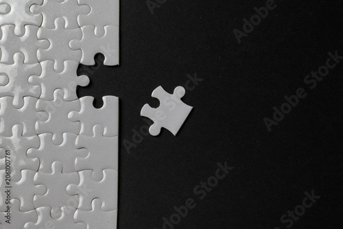 Bild auf Leinwand Missing puzzle piece concept on black background