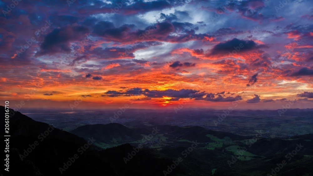 Obraz premium Vibrant sunset paints the sky with orange, purple, and deep red hues