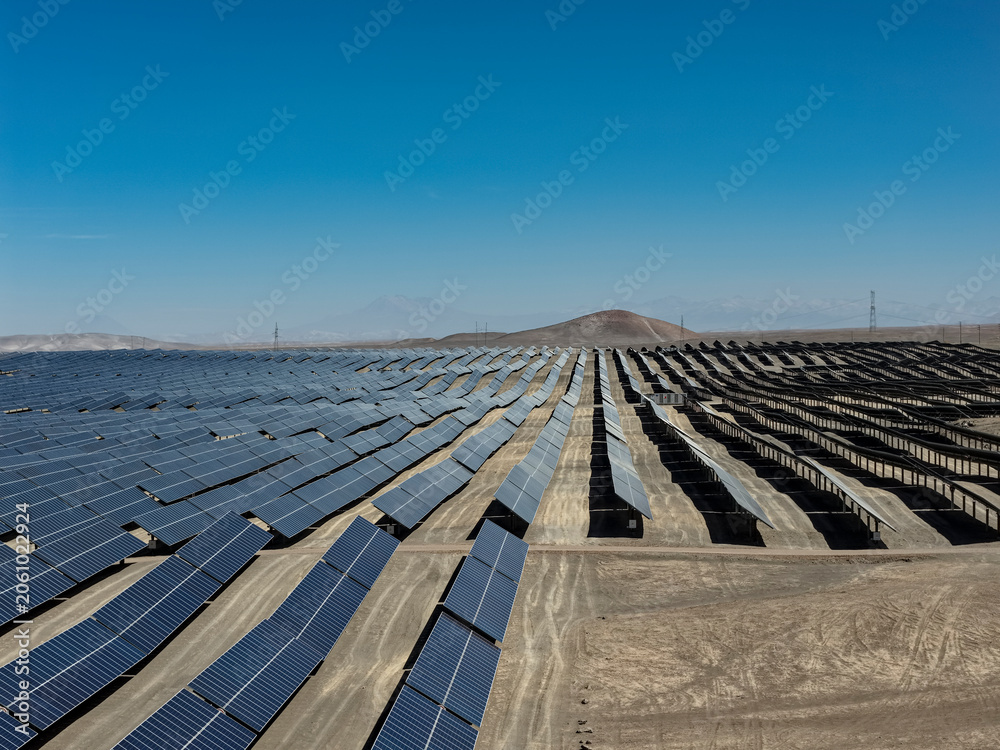 Fototapeta premium Huge photovoltaic solar park with aligned panels in a desert area