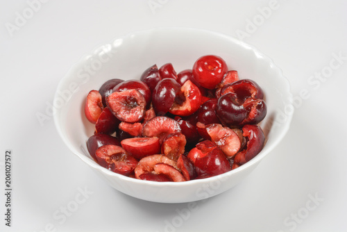 Quadro su tela A studio shot of fresh juicy red sweet cherries cut in half with pits removed an