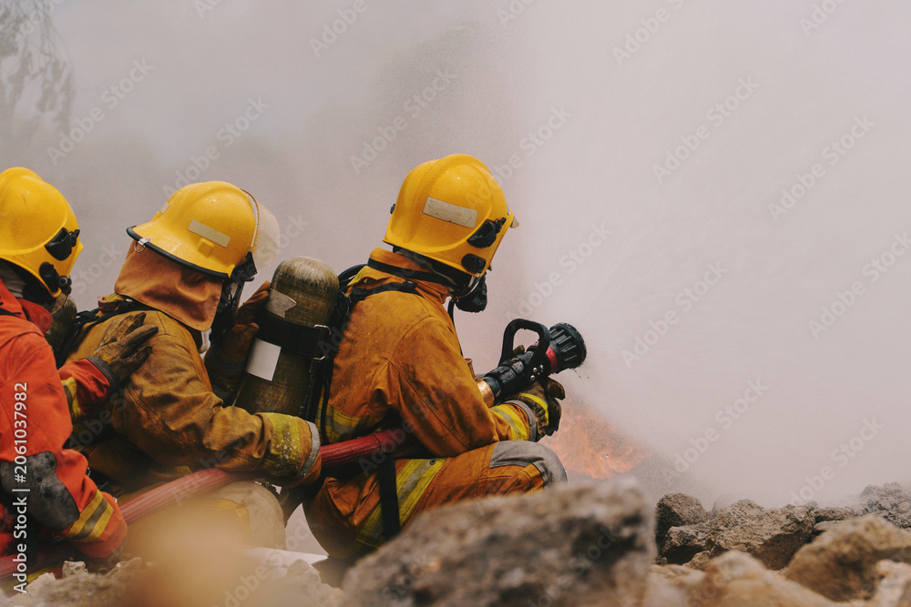 Fototapeta premium Firefighters are working together to put out the fire with water. 
