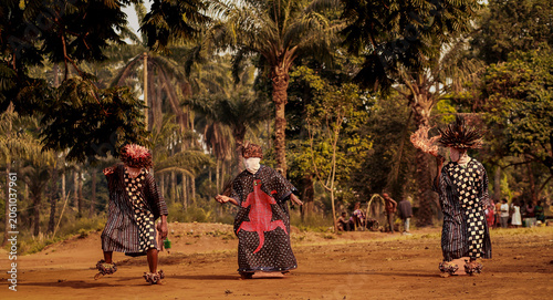 Fotografi Masked dancers, wearing woven face coverings, colorful robes, and elaborate feathered headdresses,  perform a traditional ceremonial dance in the Babungo Kingdom of Cameroon
