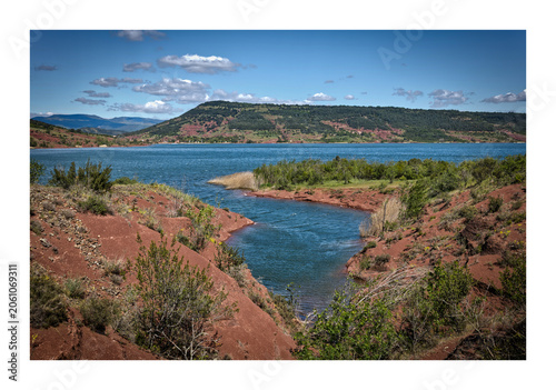 Foto Iconic red earth landscape of Lac du Salagou with blue water and hills in Southe
