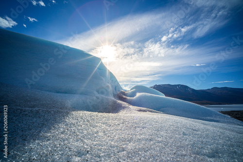 Perito moreno glaciers ice blue landscape sun over frozen ridge and mountain sky with sparkling snow in patagonia