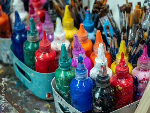 Bottles of paint and brushes are prepared for painting in the art workshop