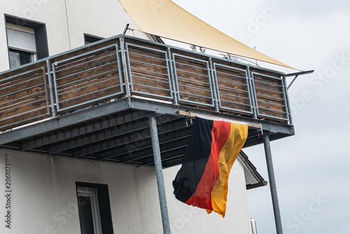 Obraz na płótnie Flag of Germany hanging from a balcony in an urban area