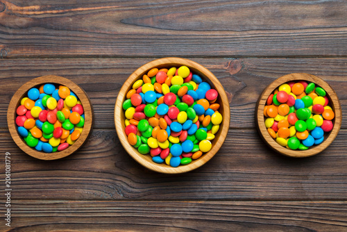 Photos different colored round candy in bowl and jars