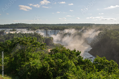 Fotografie Spectacular majestic iguazu falls surrounded by lush green tropical forest