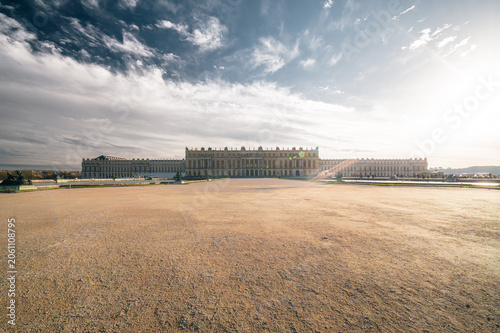 Fotografi Château de Versailles façade principale sous ciel dramatique