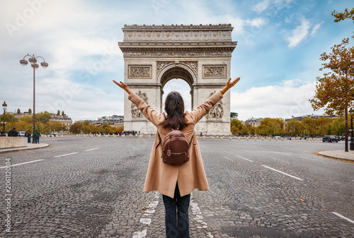 Cuadro en lienzo A happy tourist woman on a city trip stands in front of the Arc de Triomphe in P