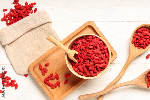 Konstfotografi Composition with tray, bag, bowl and dried goji berries on white wooden backgrou