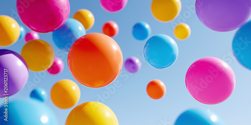 Vibrant group of colorful, glossy plastic balls floating freely against a clear blue sky background.