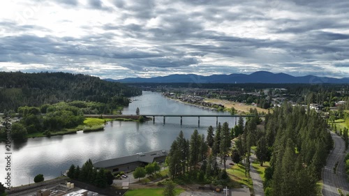 Aerial of Spokane river and highway bridge in Coeur Dalene Idaho with cloudy skies and wide mountain urban view