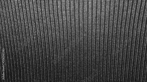 macro tracking shot reveals complex texture of dark gray knitted wool fabric shifting under dramatic cinematic lighting
