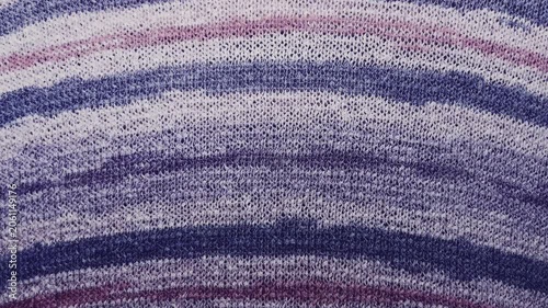 purple knitted fabric texture macro tracking slowly across striped violet wool yarn waves