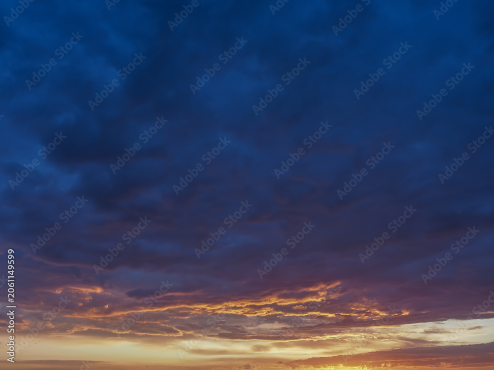 Fototapeta premium Sun rays breaking through dramatic storm clouds at sunset