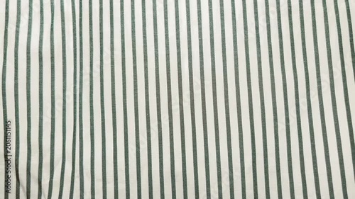 green striped linen fabric sways gently in natural light creating a calm minimalist aesthetic
