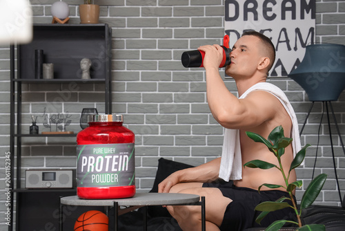 Young muscular man drinking...