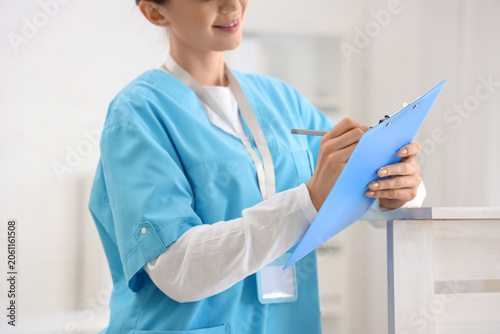 Female medical intern writi...