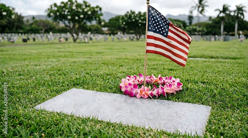 American flag and flower lei on a grave marker at a military cemetery