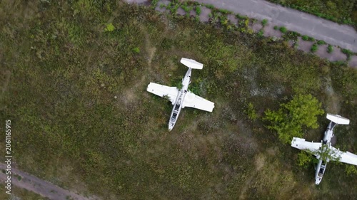 Aerial look down view of abandoned Aero L-29 Delfin trainer aircrafts parked on old overgrown airfield