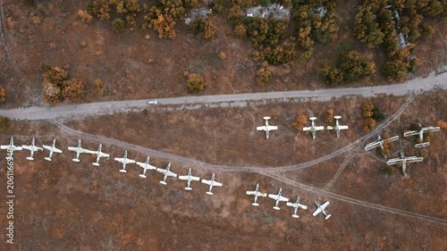 Aerial old abandoned airfield look down with weathered hangar and airplanes in autumn