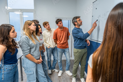 Bild auf Leinwand Teacher explaining mathematics to diverse students in classroom