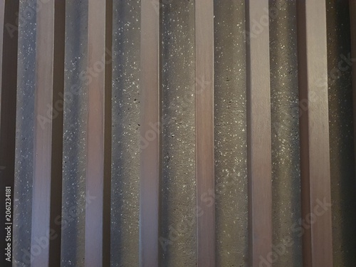 Phone photo of wooden bars positioned against a stone wall. Rustic architectural detail showing texture, natural materials, and structural contrast.